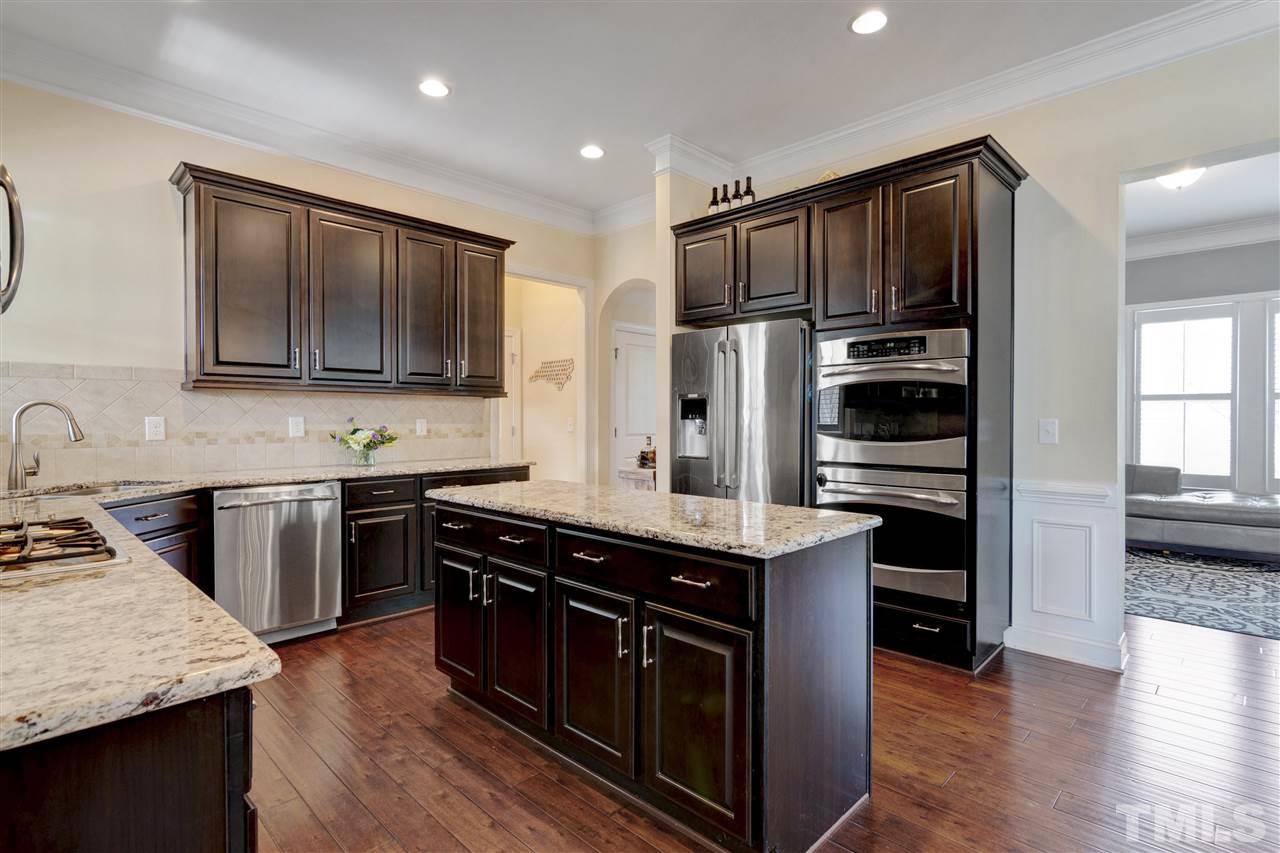 1585 Fullerton Place Raleigh, NC 27607 - Photo 11 of 30 a kitchen with stainless steel appliances kitchen island granite countertop a stove a sink and a refrigerator