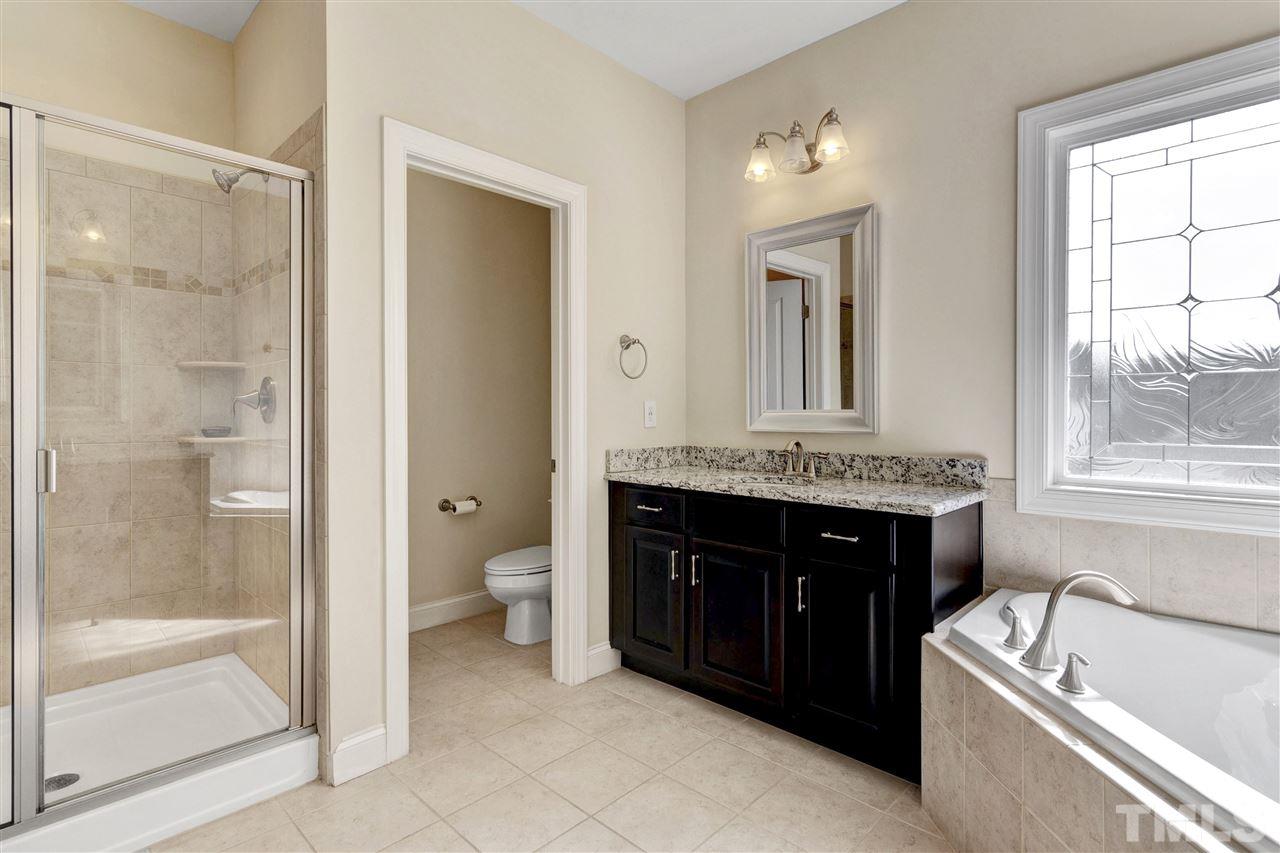 1585 Fullerton Place Raleigh, NC 27607 - Photo 22 of 30 a bathroom with a granite countertop tub sink and mirror