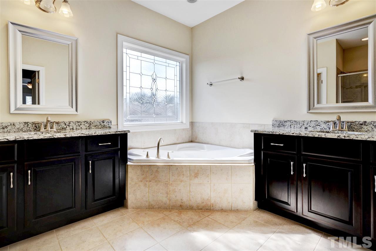 1585 Fullerton Place Raleigh, NC 27607 - Photo 23 of 30 a bathroom with a tub sink and mirror