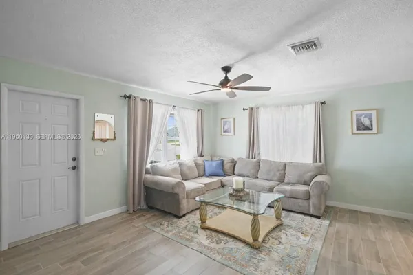 a living room with furniture and wooden floor