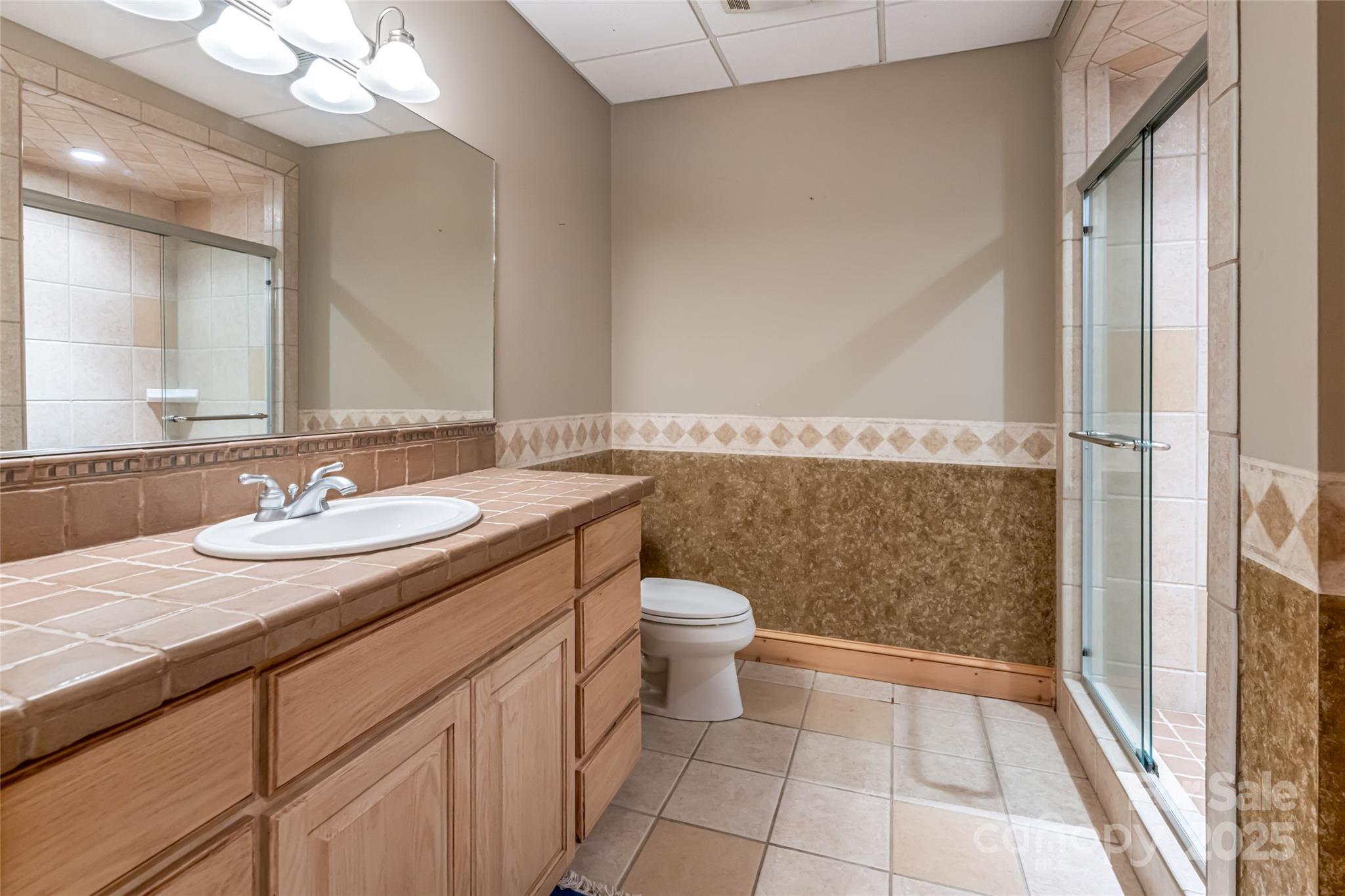 303 Flying Hawk Road Waynesville, NC 28786 - Photo 36 of 48 a bathroom with a granite countertop sink toilet and shower