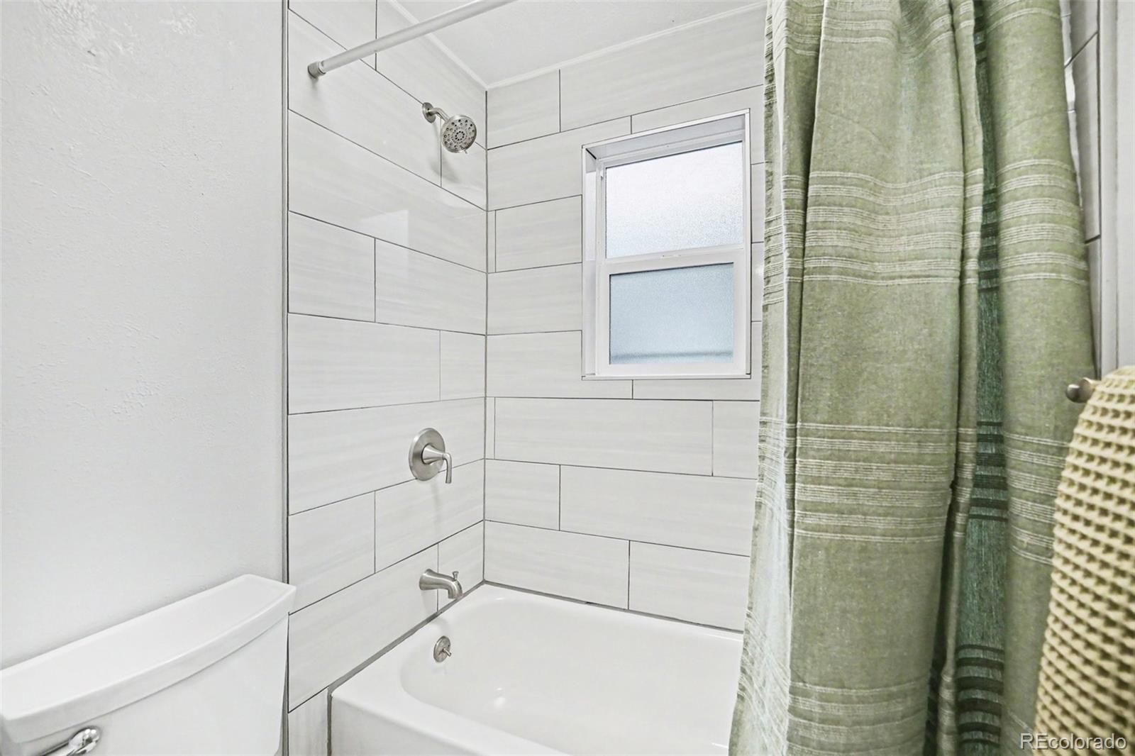 5700 West 28th Avenue, Unit 1 Wheat Ridge, CO 80214 - Photo 9 of 25 a bathroom with a bathtub and shower