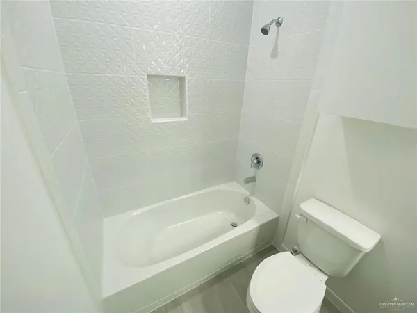 a white toilet sitting next to a bath tub