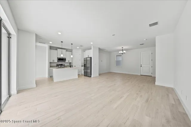a view of a kitchen with refrigerator and white cabinets
