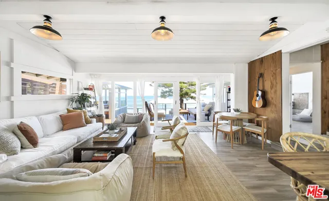 a living room with furniture a flat screen tv and a large window