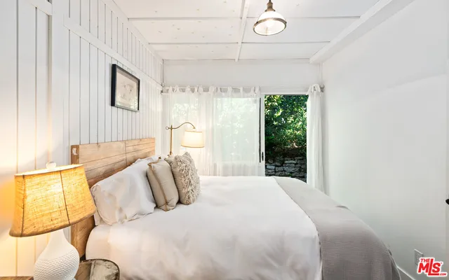 a backyard of a house with wooden fence and large trees