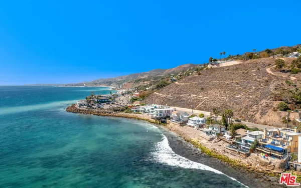 a view of a patio with chairs under an umbrella