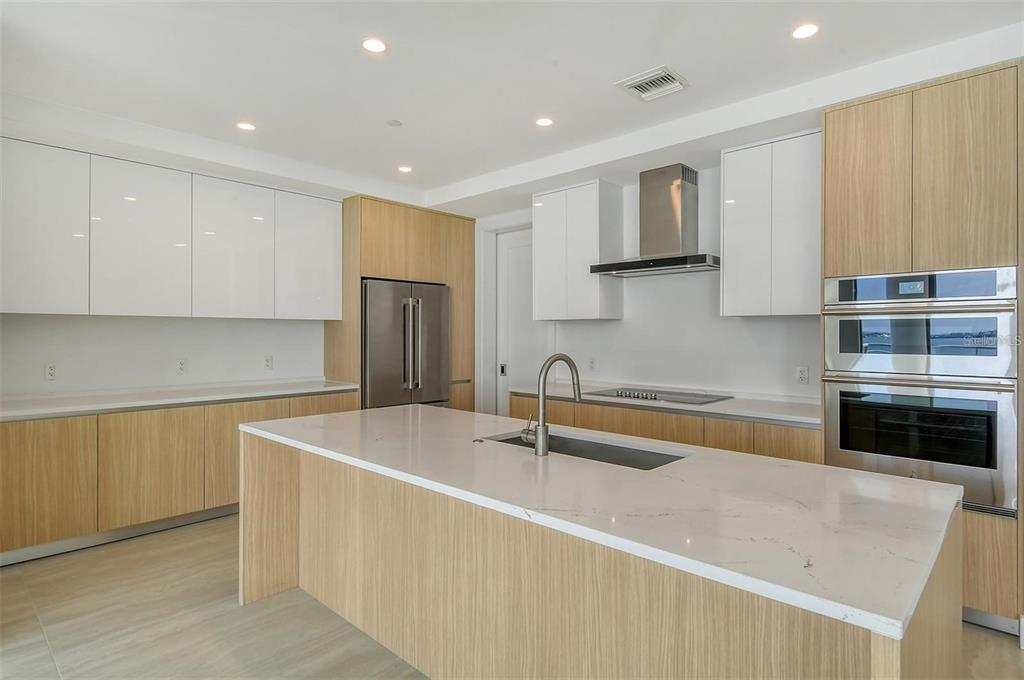 301 Quay Commons, Unit 1011 Sarasota, FL 34236 - Photo 14 of 75 a kitchen with stainless steel appliances granite countertop a sink a stove a refrigerator a microwave a sink and white cabinets