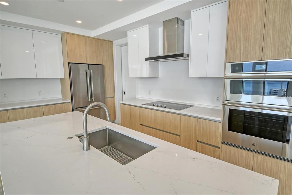 301 Quay Commons, Unit 1011 Sarasota, FL 34236 - Photo 15 of 75 a kitchen with stainless steel appliances granite countertop a refrigerator and a stove top oven