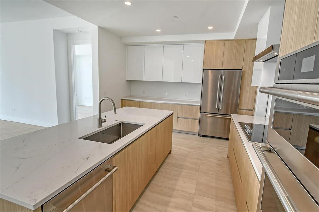 301 Quay Commons, Unit 1011 Sarasota, FL 34236 - Photo 17 of 75 a kitchen with refrigerator cabinets and a sink