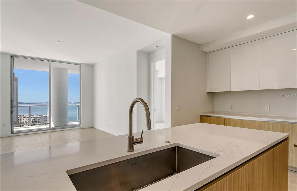 301 Quay Commons, Unit 1011 Sarasota, FL 34236 - Photo 18 of 75 a kitchen with a sink a counter top space and cabinets