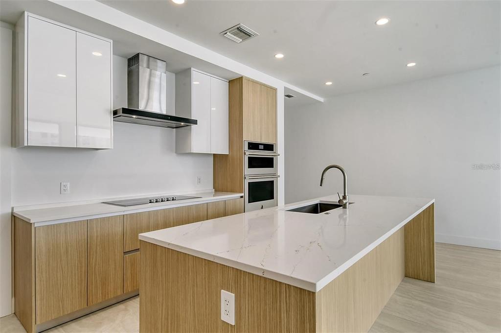 301 Quay Commons, Unit 1011 Sarasota, FL 34236 - Photo 19 of 75 a kitchen with a sink a counter top space cabinets and stainless steel appliances