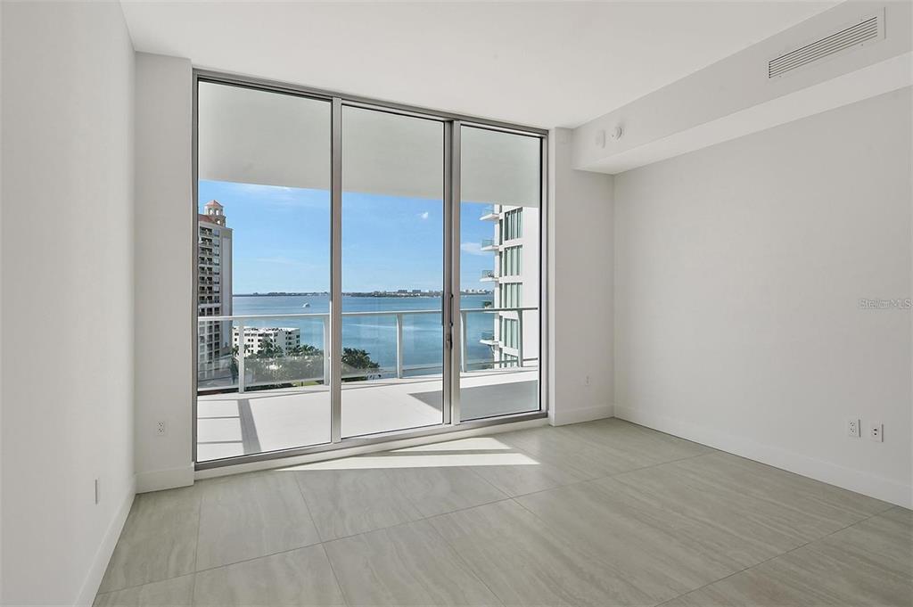 301 Quay Commons, Unit 1011 Sarasota, FL 34236 - Photo 22 of 75 a view of an empty room with wooden floor and a window