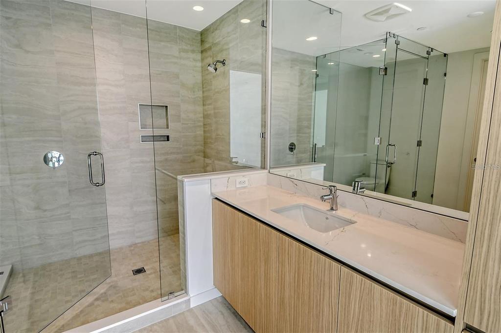 301 Quay Commons, Unit 1011 Sarasota, FL 34236 - Photo 24 of 75 a bathroom with a shower sink and mirror