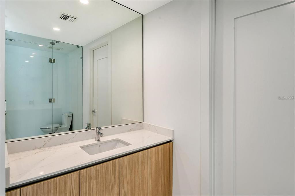 301 Quay Commons, Unit 1011 Sarasota, FL 34236 - Photo 26 of 75 a bathroom with a granite countertop sink and a mirror