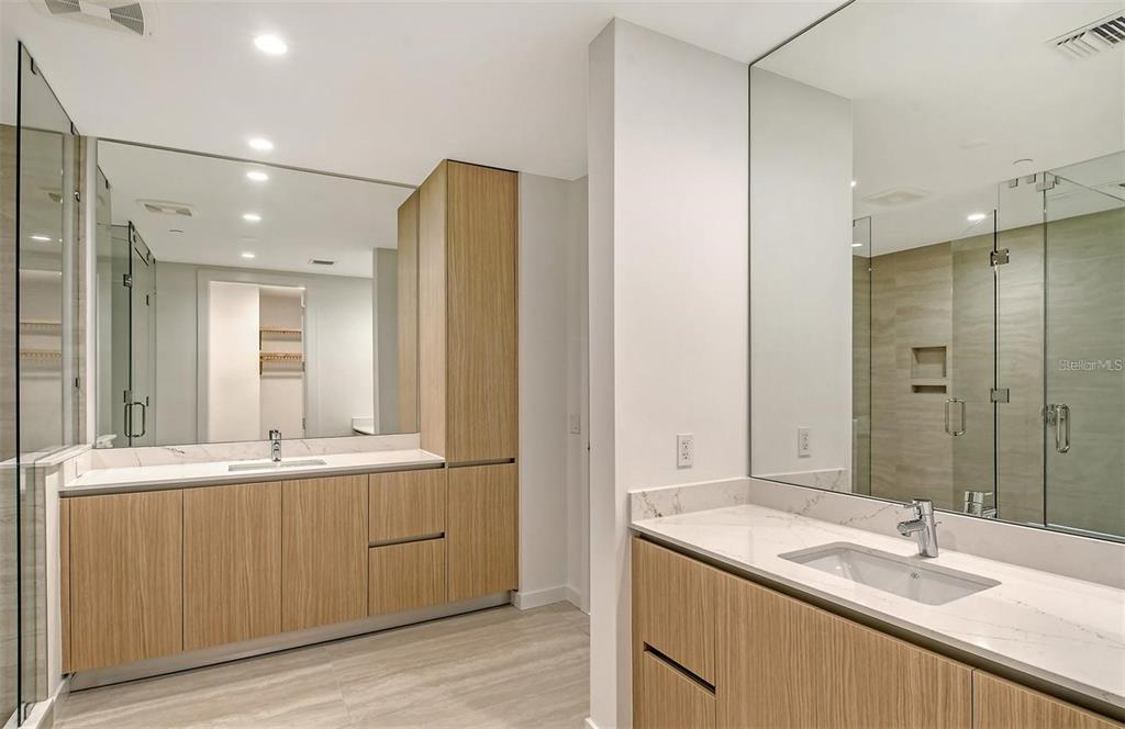 301 Quay Commons, Unit 1011 Sarasota, FL 34236 - Photo 28 of 75 a bathroom with a granite countertop sink and a mirror