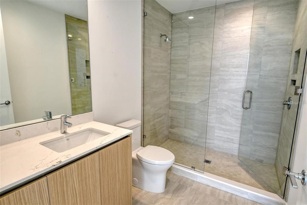 301 Quay Commons, Unit 1011 Sarasota, FL 34236 - Photo 31 of 75 a bathroom with a sink toilet and shower