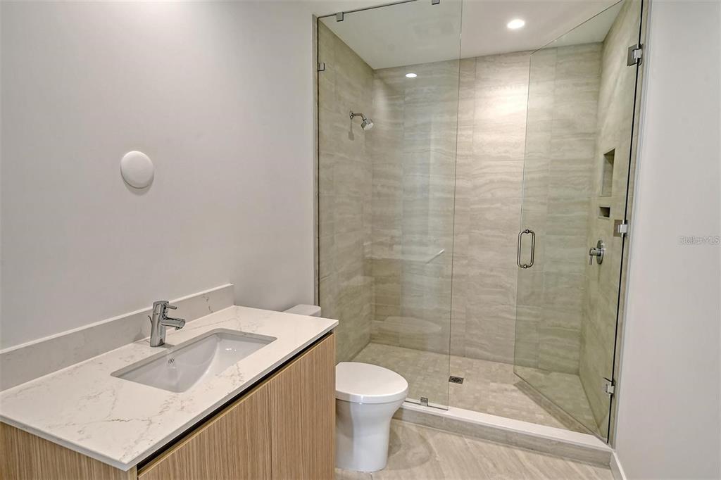 301 Quay Commons, Unit 1011 Sarasota, FL 34236 - Photo 34 of 75 a bathroom with a granite countertop sink toilet and shower