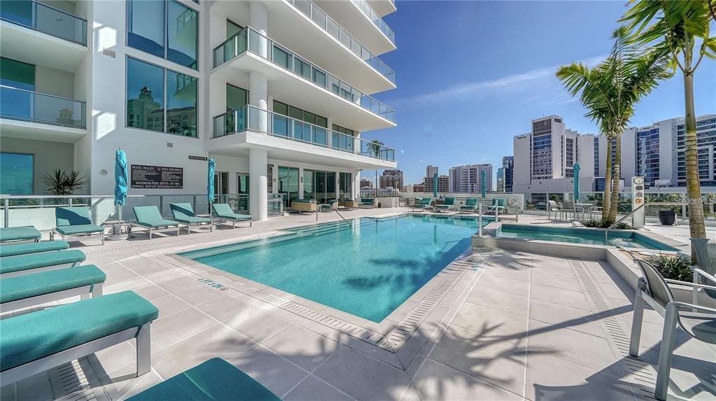 301 Quay Commons, Unit 1011 Sarasota, FL 34236 - Photo 74 of 75 a view of a patio with couches and table and chairs with plants and trees