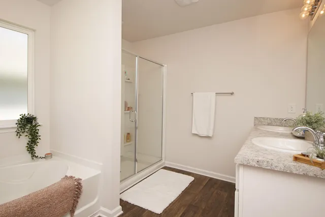 a bathroom with a granite countertop sink a mirror and shower