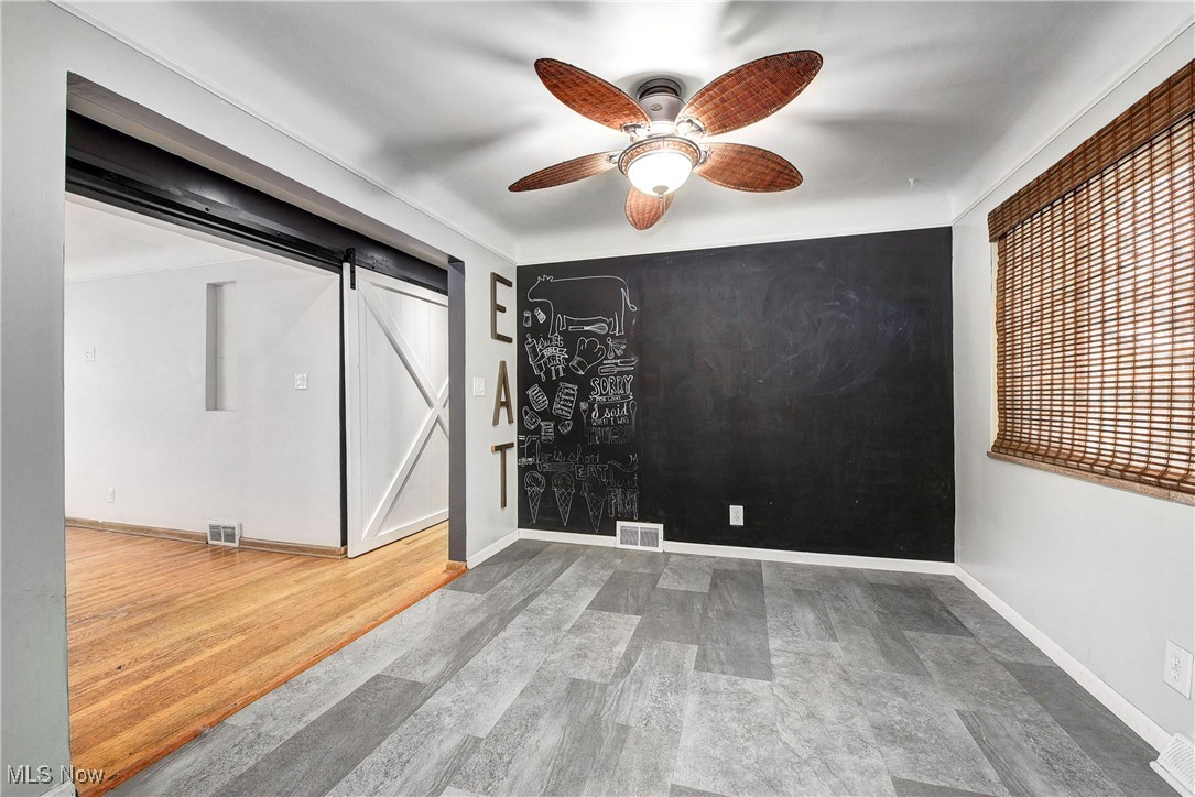 11518 Prospect Road Strongsville, OH 44149 - Photo 11 of 46 Spare room with baseboards, a barn door, ceiling fan, visible vents, and wood finished floors