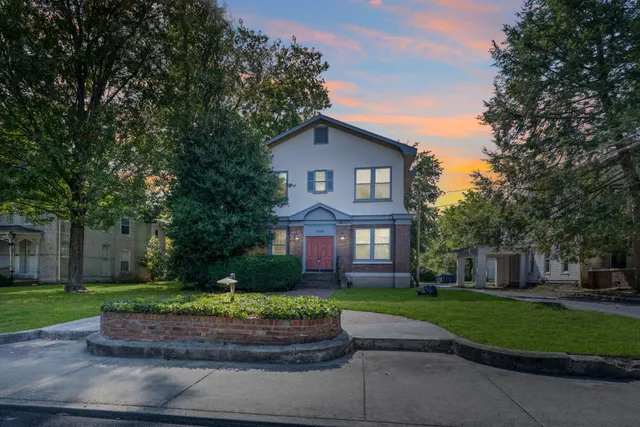 a front view of a house with a yard and trees