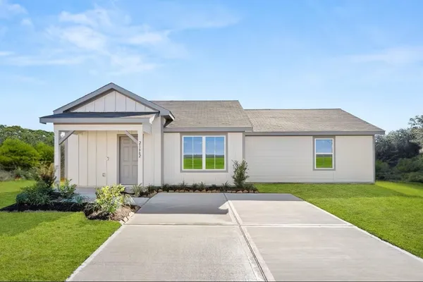 a front view of a house with a garden and yard