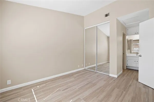 an empty room with wooden floor and a bathroom