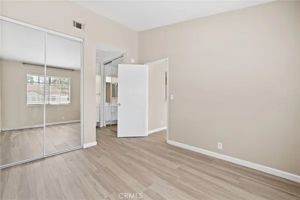 an empty room with wooden floor and a window