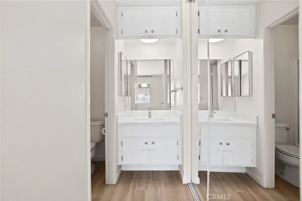 an empty room with wooden floor and mirror