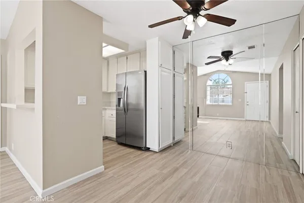 a view of a hallway with wooden floor and a cabinet