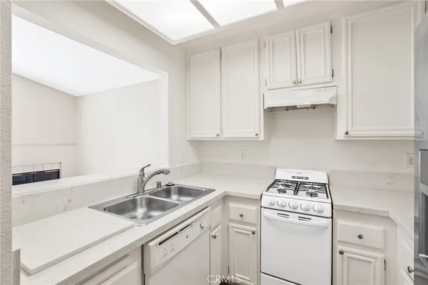 a kitchen with white cabinets and white appliances