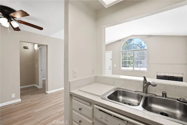 a kitchen with a sink a refrigerator and wooden floor