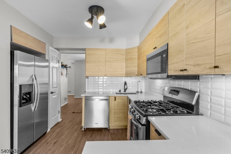 23 Bayowski Road West Orange, NJ 07052 - Photo 6 of 38 a kitchen with stainless steel appliances granite countertop a refrigerator a stove microwave and cabinets