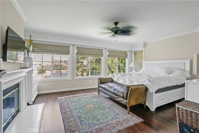 a spacious bedroom with a large bed a flat tv screen and a dresser