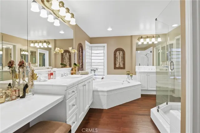 a bathroom with a double vanity sink mirror and bathtub