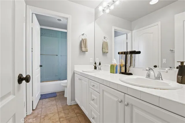 a bathroom with a double vanity sink a mirror and a shower