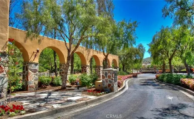 a view of a park with potted plants and large trees