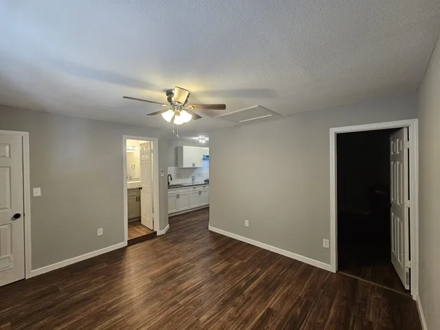 a view of a livingroom with a ceiling fan & wooden floor