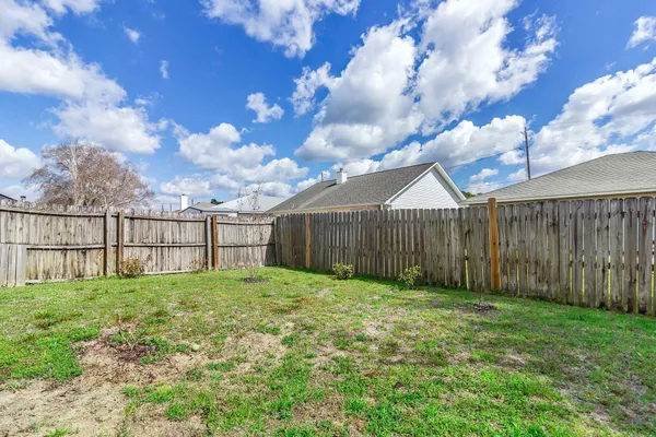 a view of a backyard with wooden fence