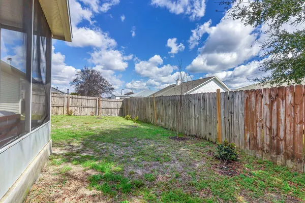 a view of backyard with wooden fence