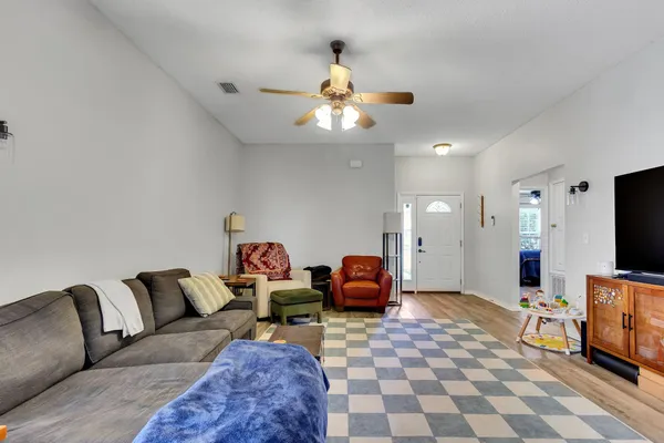 a living room with furniture a flat screen tv and a chandelier