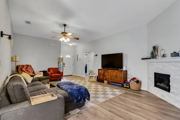 a living room with furniture a flat screen tv and a fireplace