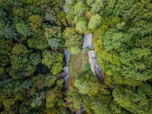 an aerial view of a house with swimming pool and sitting area