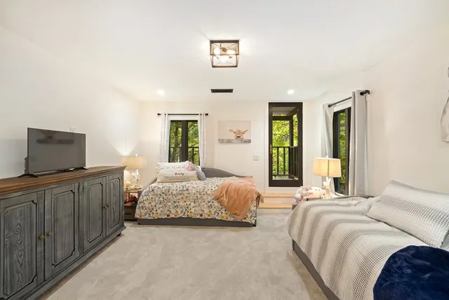 a living room with furniture a flat screen tv and a chandelier