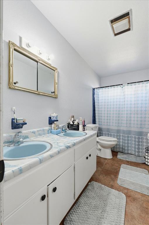 54 Gardner Avenue Lake Wales, FL 33898 - Photo 11 of 25 a bathroom with a double vanity sink toilet and a mirror