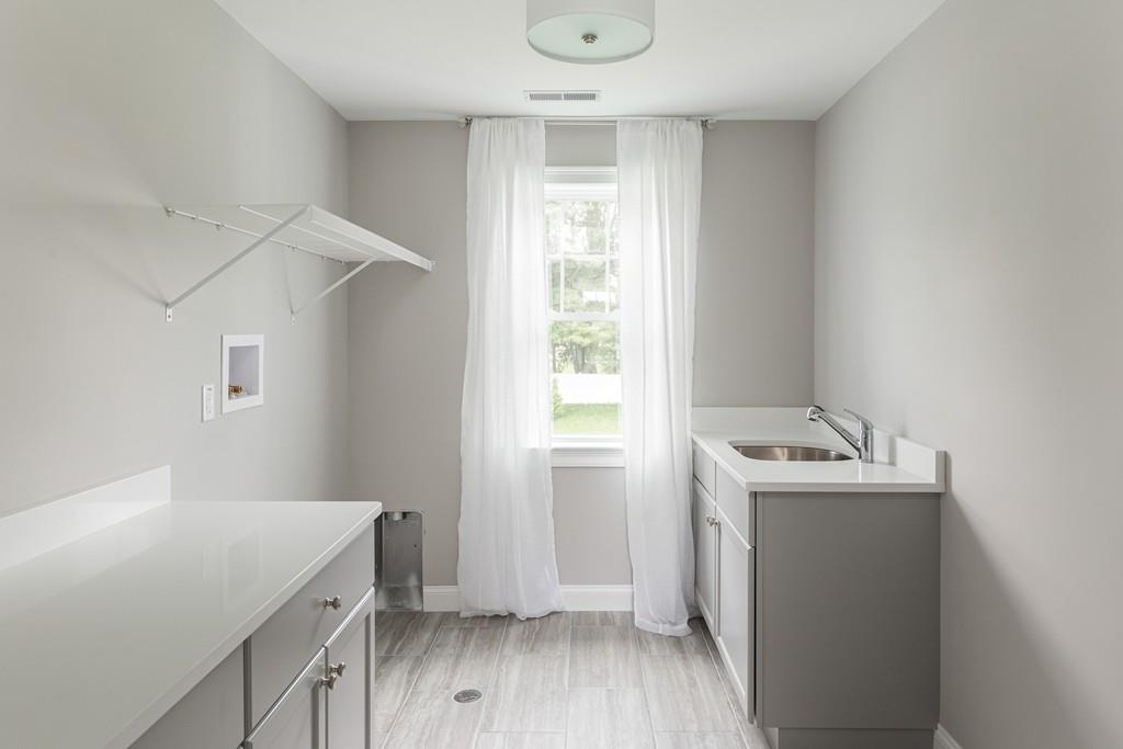 7 Summit Pointe Drive Holliston, MA 01746 - Photo 12 of 24 a storage room with wooden floor washer and dryer