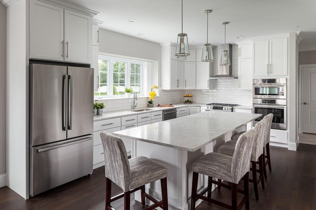 7 Summit Pointe Drive Holliston, MA 01746 - Photo 2 of 24 a kitchen with stainless steel appliances granite countertop a refrigerator a sink a stove a dining table and chairs