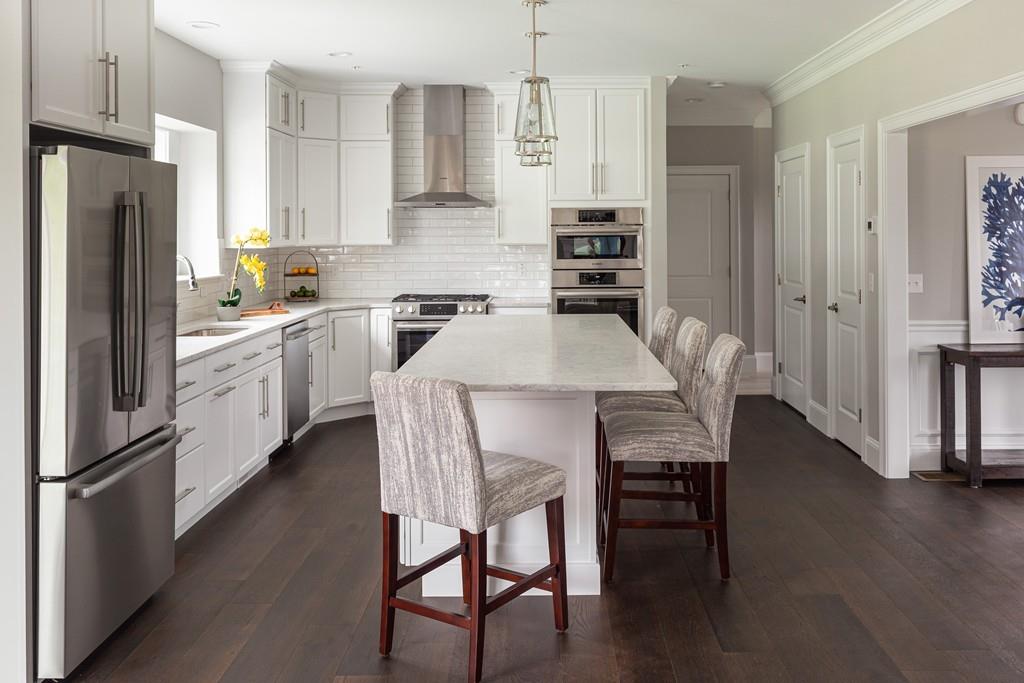 7 Summit Pointe Drive Holliston, MA 01746 - Photo 3 of 24 a kitchen with stainless steel appliances a dining table chairs refrigerator and sink