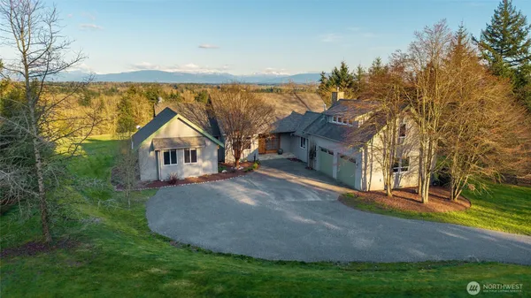 a front view of a house with a yard and lake view